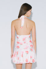 Back view of pink floral halter mini dress with tie neckline and open back